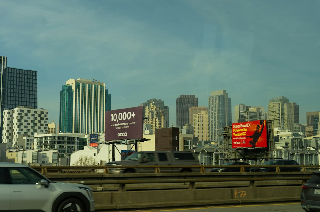 Large outdoor advertising billboard against a city skyline