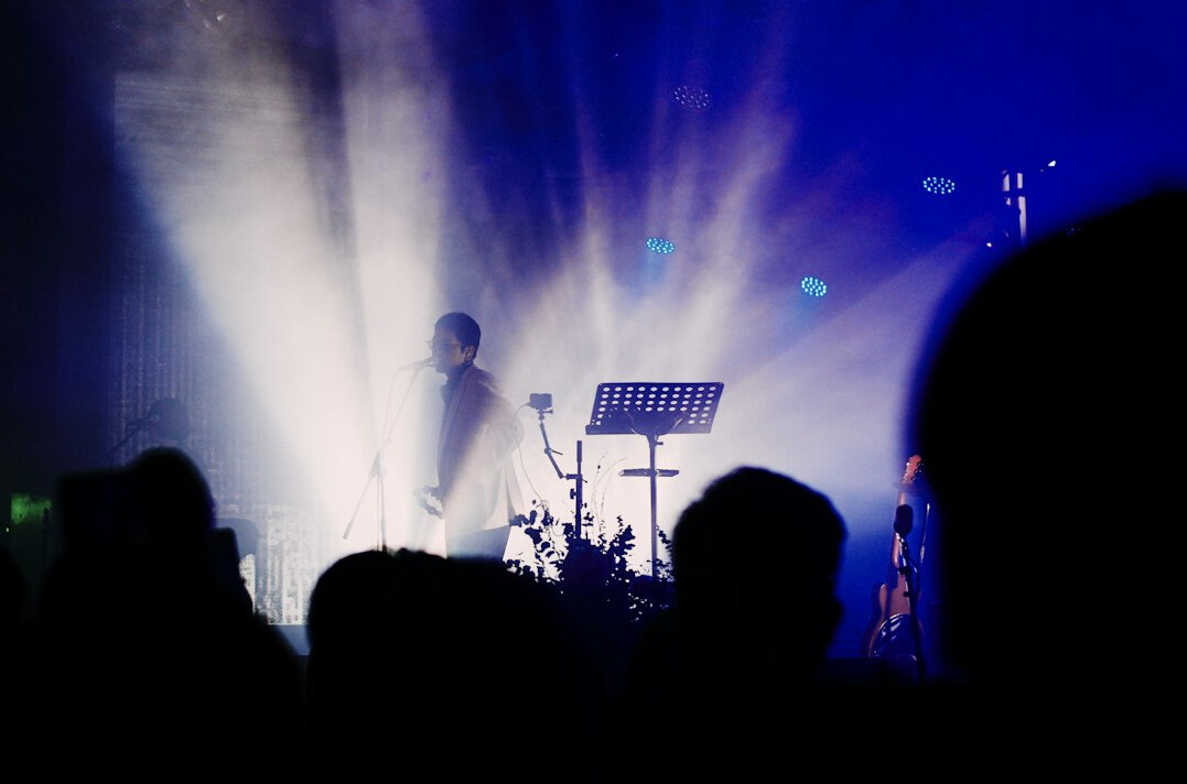Concert stage with colorful lights and silhouetted crowd